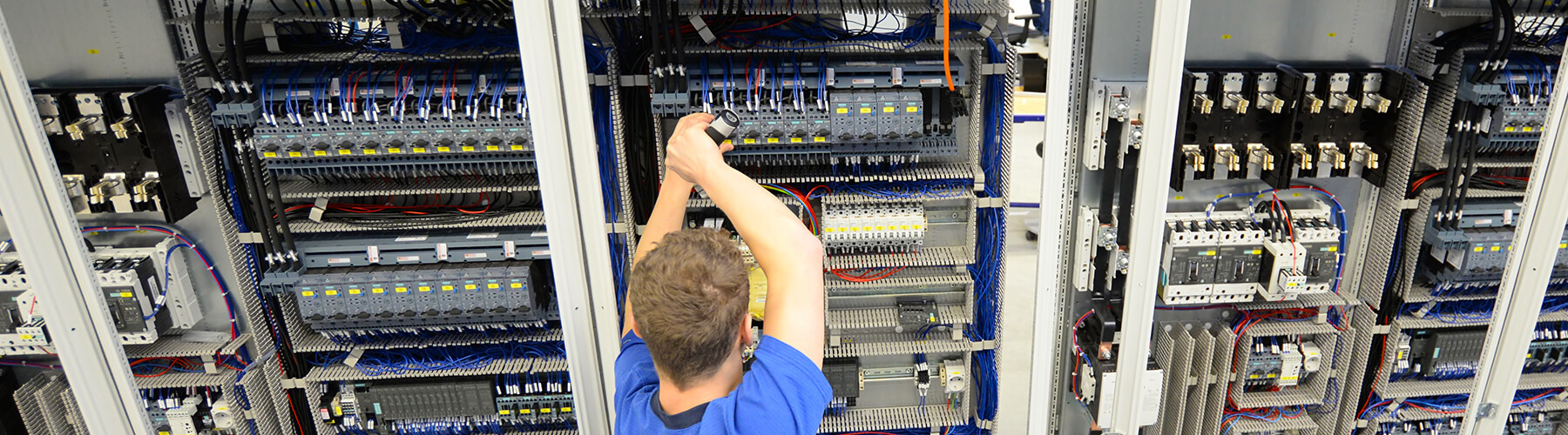 Ein Arbeiter arbeitet an einem Schaltschrank