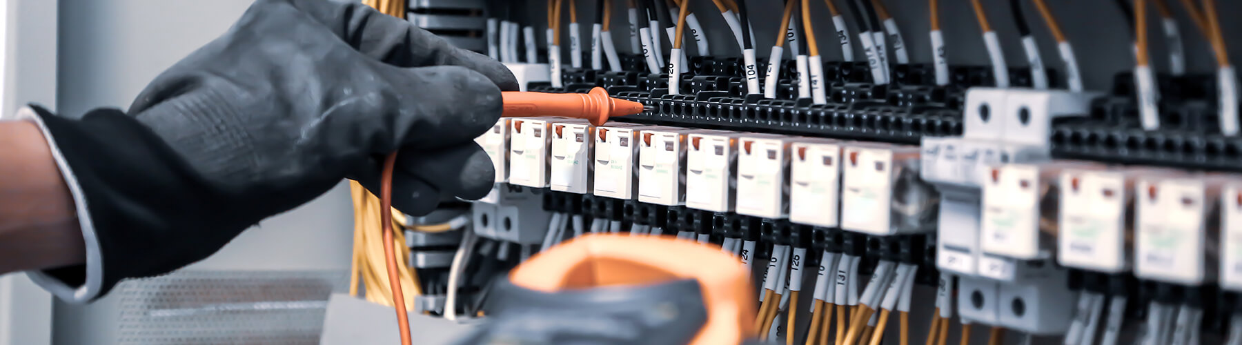 Eine Person arbeitet an verschiedenen Kabelleitungen. Wird als Slider zur Messtechnik verwendet