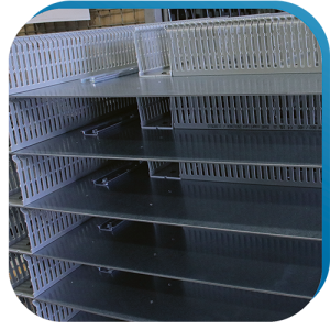 Verdrahtungskanäle und Hutschienen, die auf Montageplatten vormontiert wurden, als vorbereitenden Schritt für individuelle Gehäuselösungen.